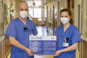 Zwei Personen halten ein Zertifikat