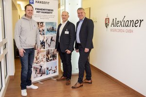 Drei Männer stehen vor einem Roll-Up Display