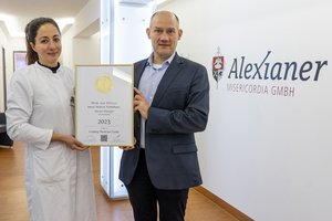 Dr. Kaya und Hr. Büscher mit der Urkunde