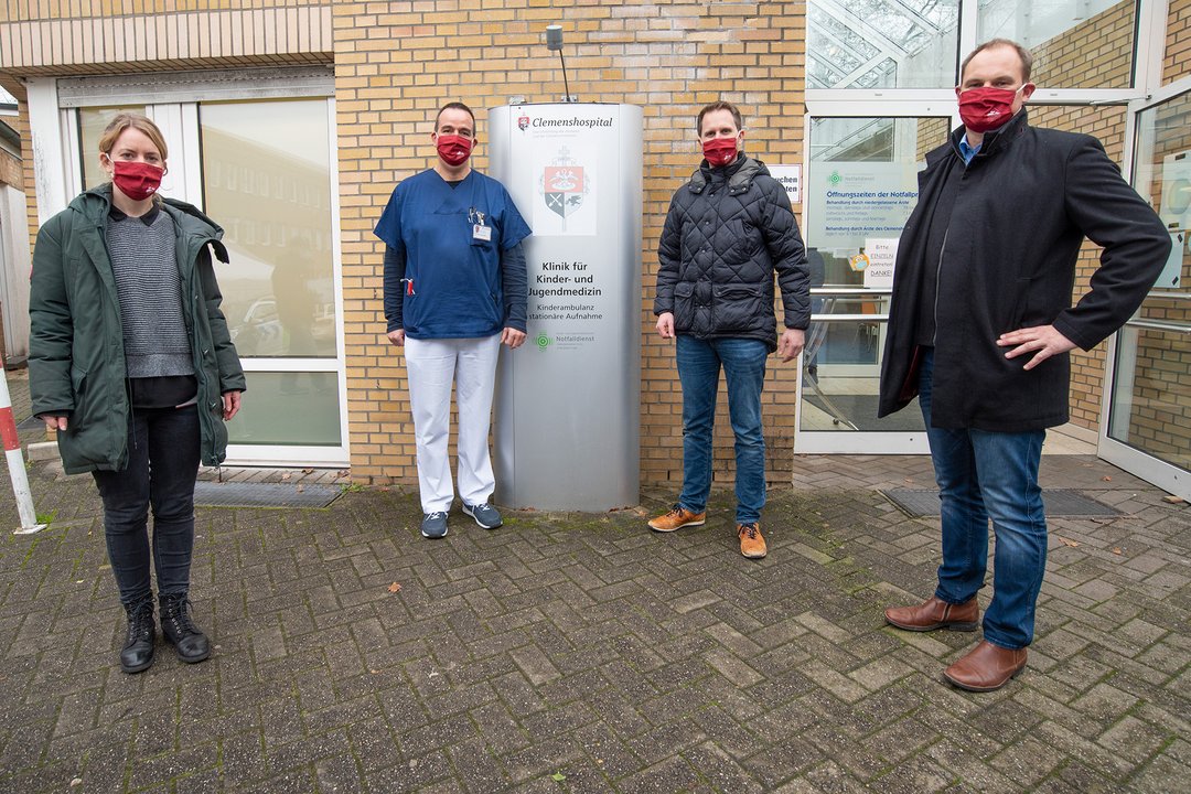 Vier Personen stehen vor der Kinderklinik