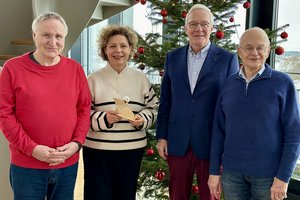 Mehrere Personen stehen vor einem Weihnachtsbaum