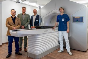 Vier Personen stehen um ein großes medizinisches Gerät herum