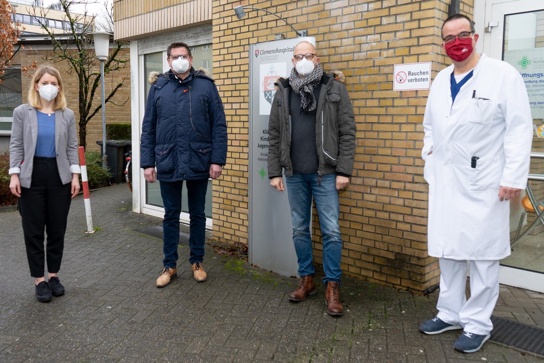 Vier Personen stehen vor der Kinderambulanz