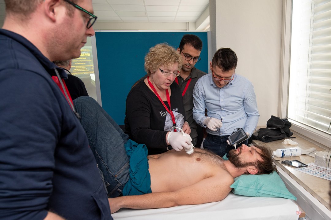 Mehrere Personen beobachten, wie eine Ultraschalluntersuchung durchgeführt wird