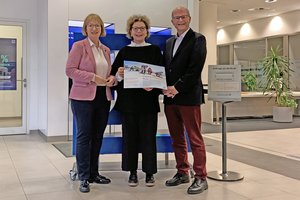 Drei Personen halten einen gro0en Scheck in der Hand