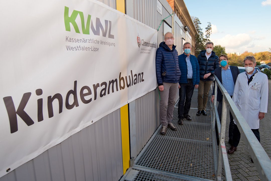 Mehrere Männer stehen neben dem Schild Kindernotdienst