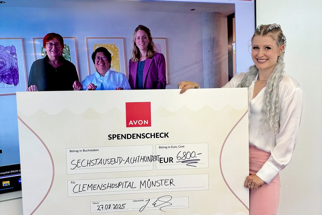 Eine Frau hält einen großen Scheck